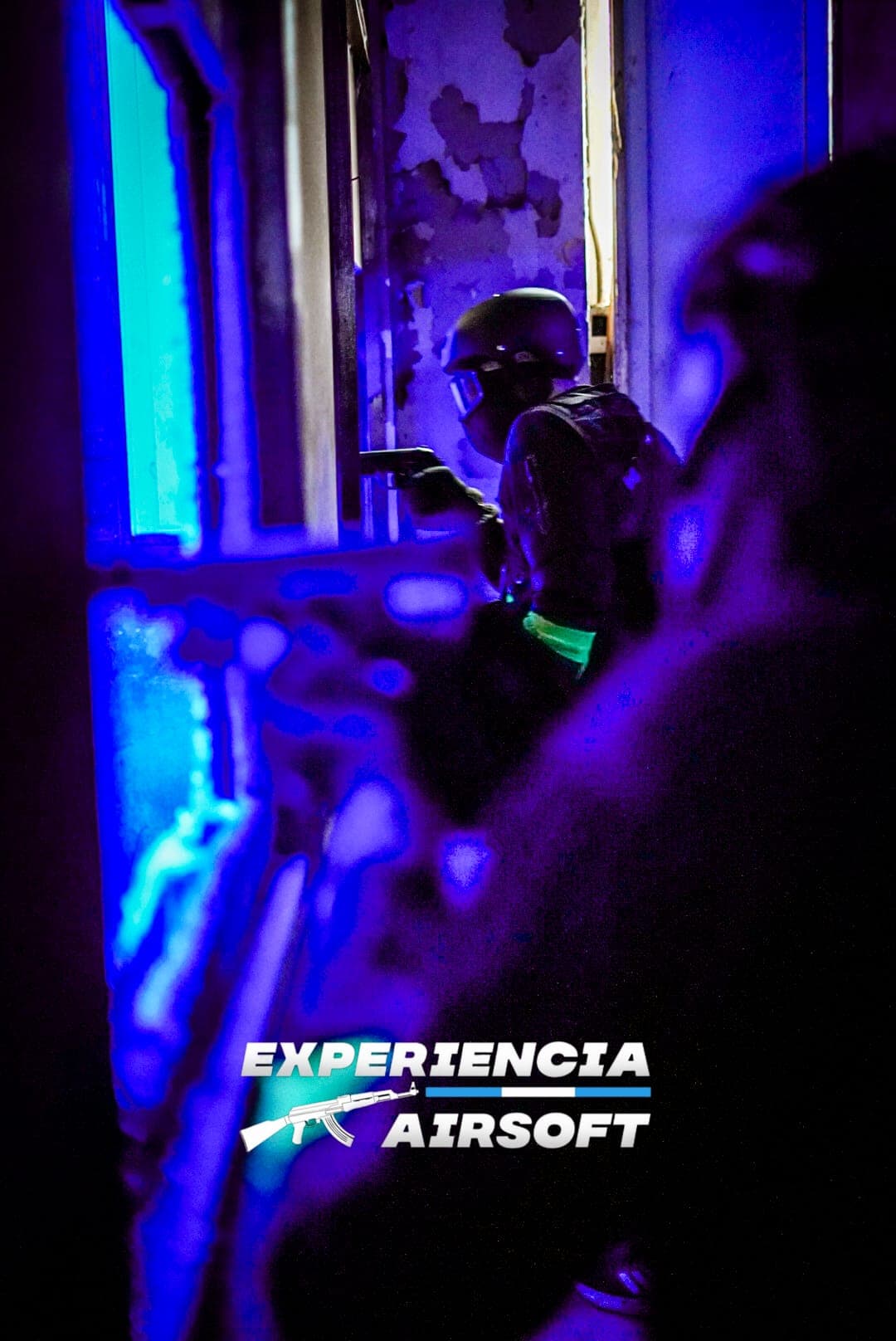 Partida nocturna de airsoft CQB con iluminación tenue y jugadores tácticos